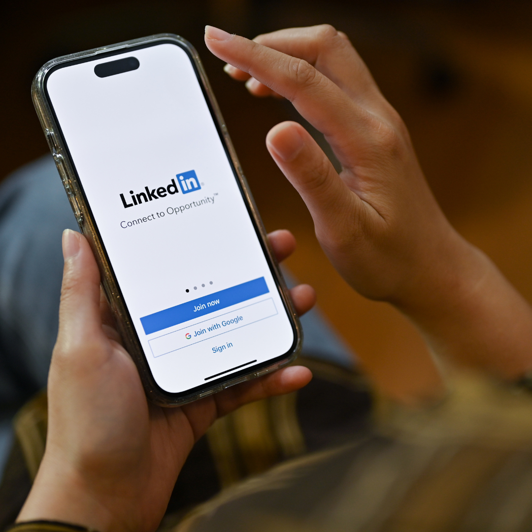 Person holding phone with LinkedIn app